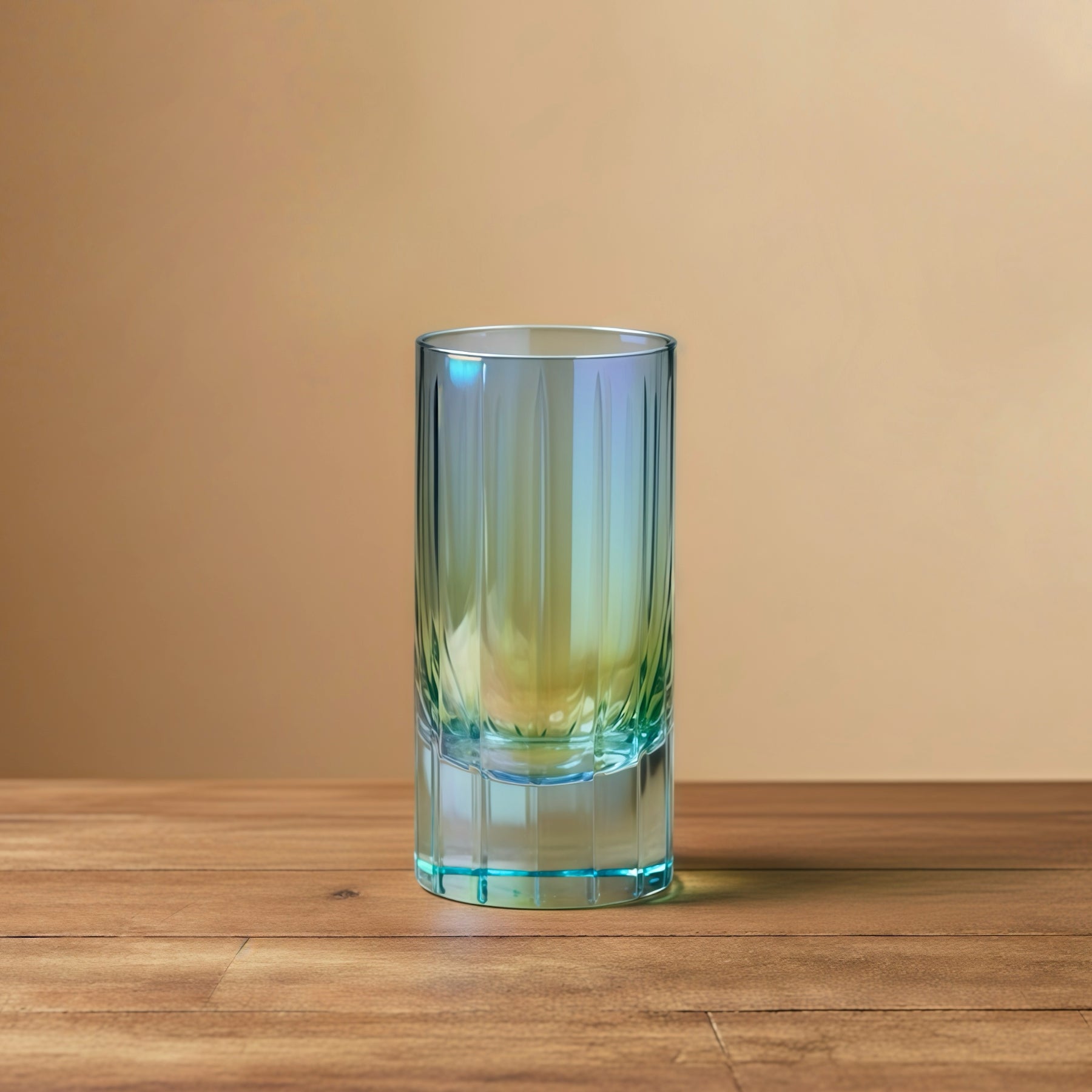 The Hand-Finished Prismatic Crystal Highball Glass in iridescent green, casting colorful shimmering caustics in the sunlight.