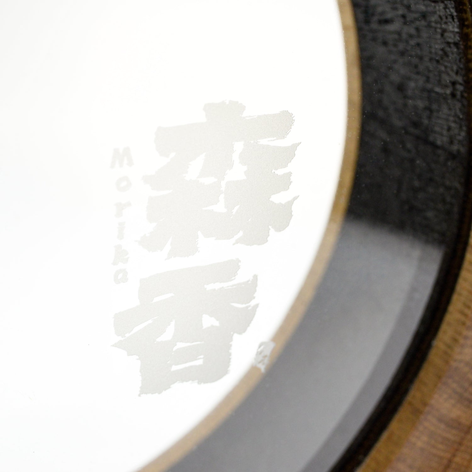 A close-up macro shot of the 'Morika' brand logo etched onto the glass of the Visual Aging Oak Barrel Decanter.