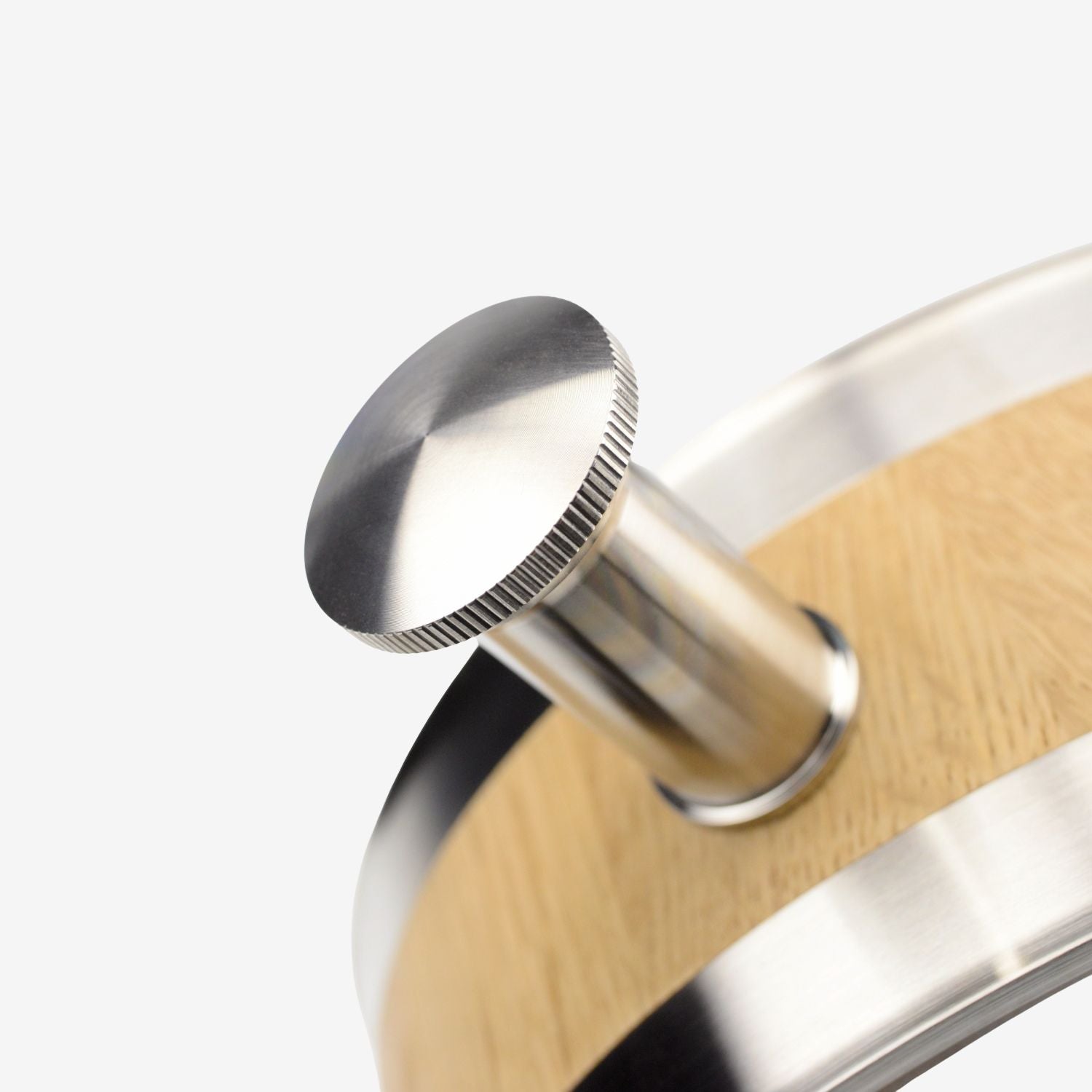 A detailed view of the precision-machined stainless steel stopper of the oak barrel decanter, showing the fine knurled edge.

