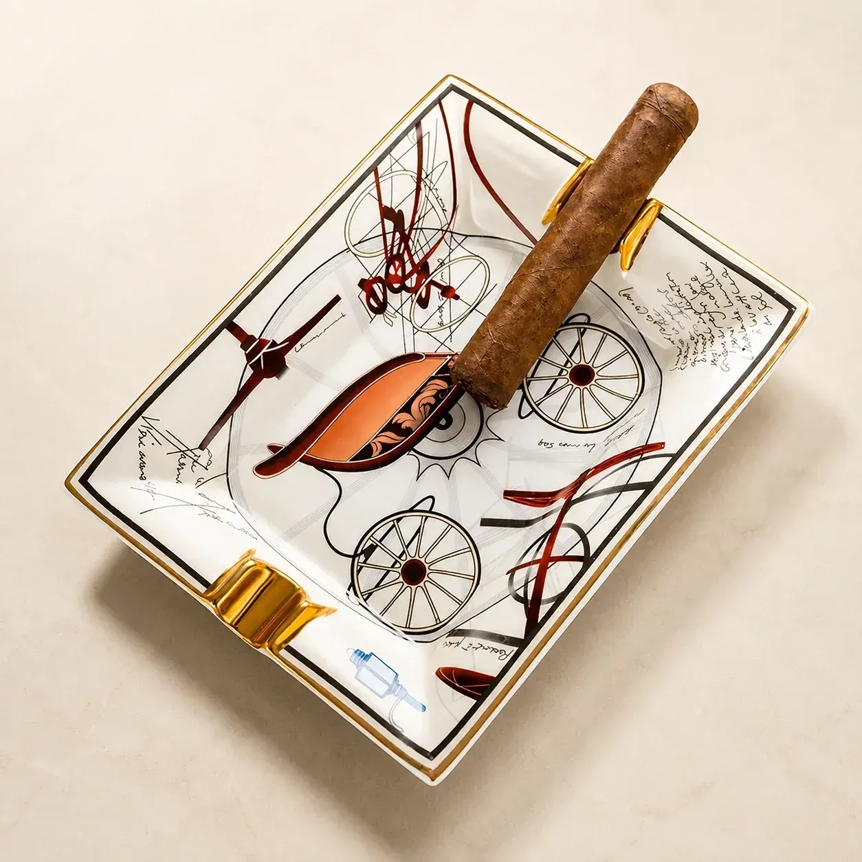 Product view of sketch-art ceramic cigar ashtray with gold rests on marble
