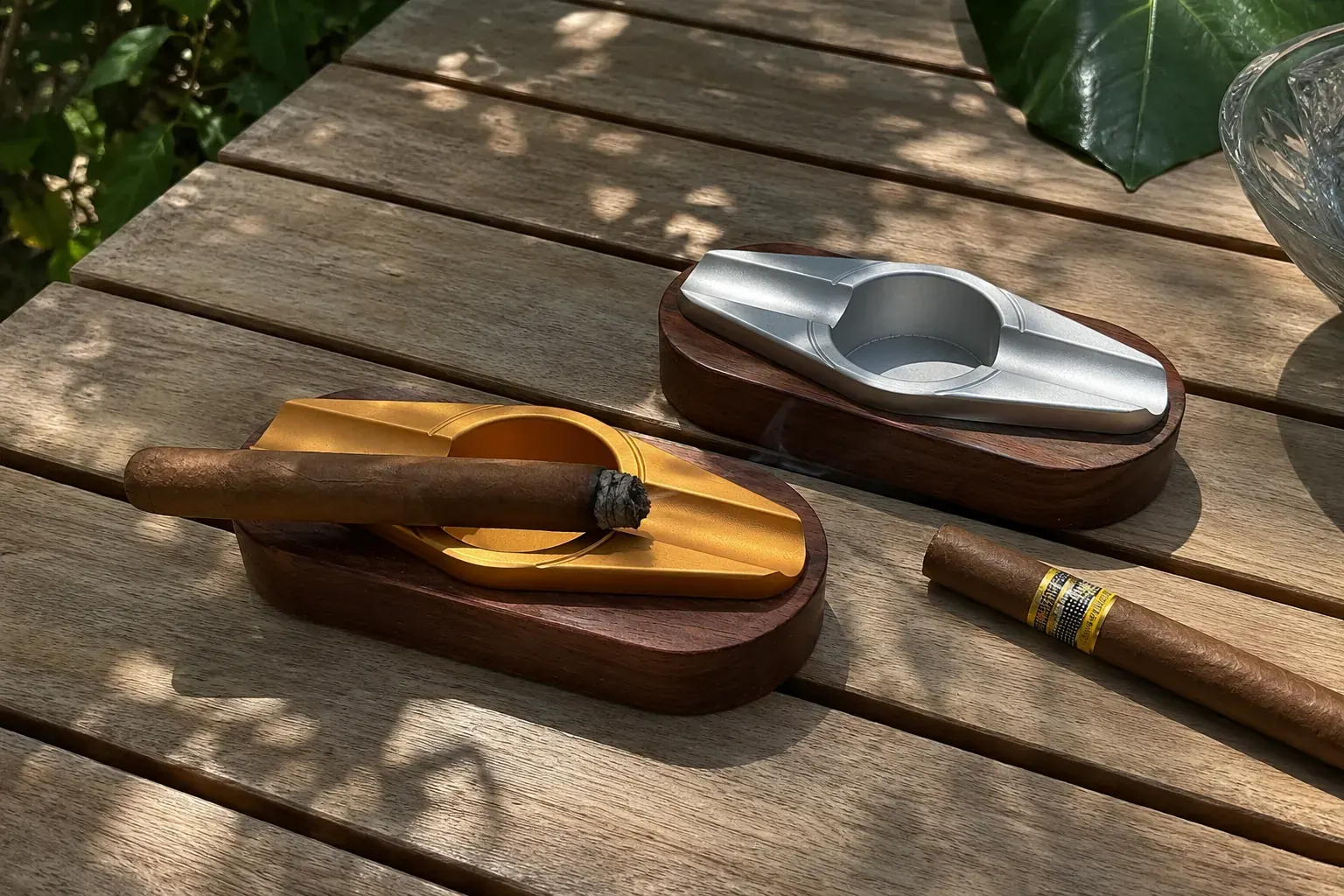 Elegant gold- and silver-finish aluminium double-rest cigar ashtrays on a slatted wood table