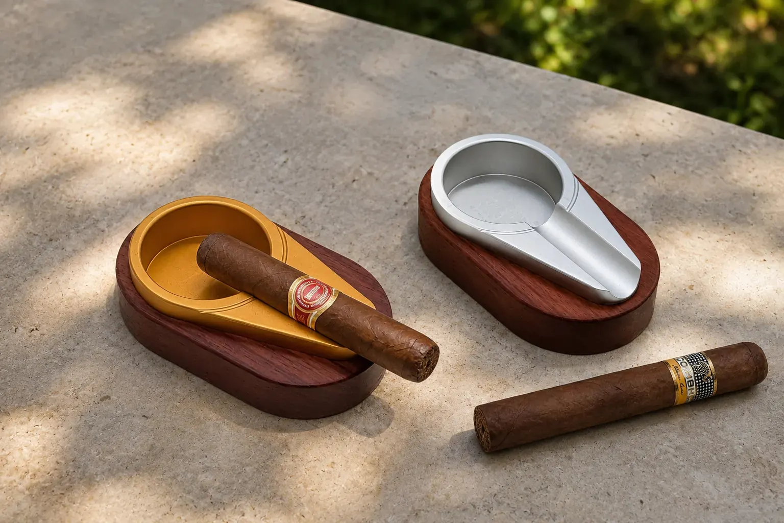 Elegant gold- and silver-finish aluminium single-rest cigar ashtrays with cigars on a stone table
