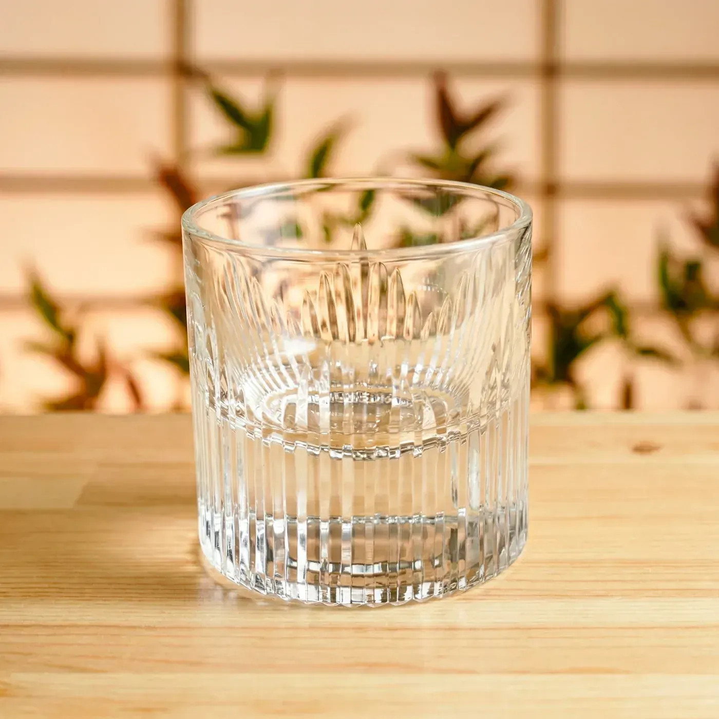 Clear Edo Kiriko tumbler with radiating flame-cut pattern in a Japanese interior