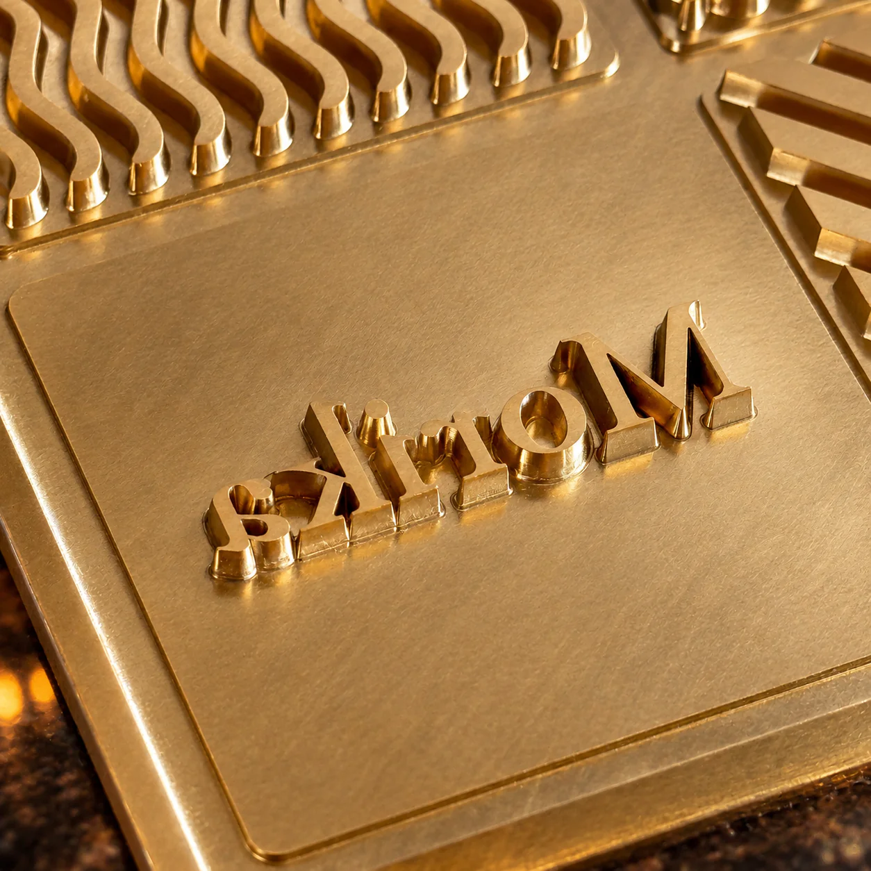 Close view of a copper ice-stamp plate cut with a raised brand logo