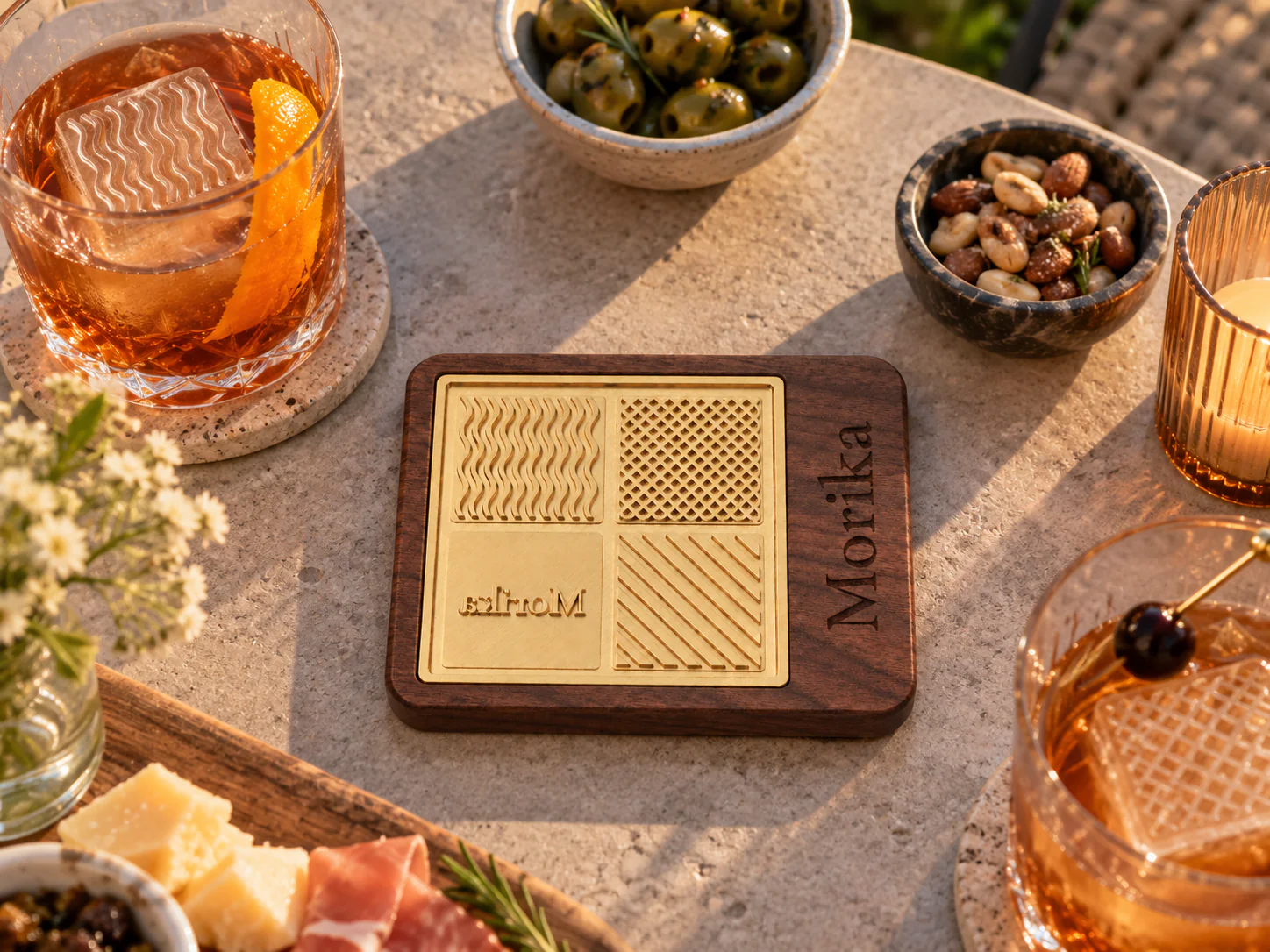 Ice branding stamp on a tasting table with cocktails, olives, and charcuterie