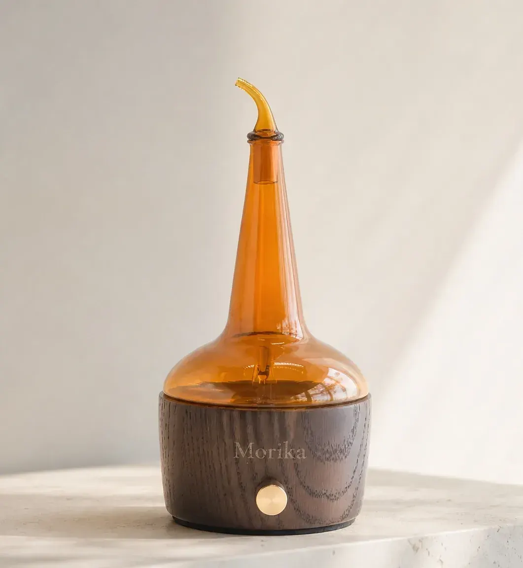 Pot still-shaped whiskey nosing diffuser with laser-engraved distillery logo on solid oak base